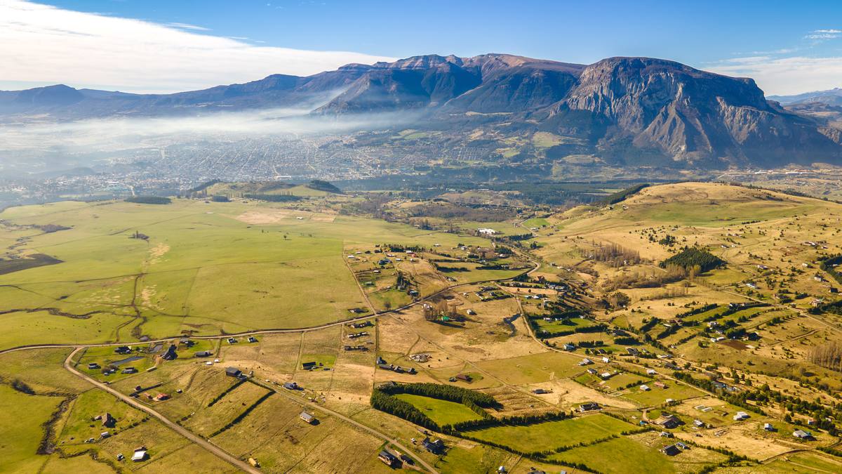 Vista aérea del valle de Coyhaique con niebla baja y el Cerro Mackay