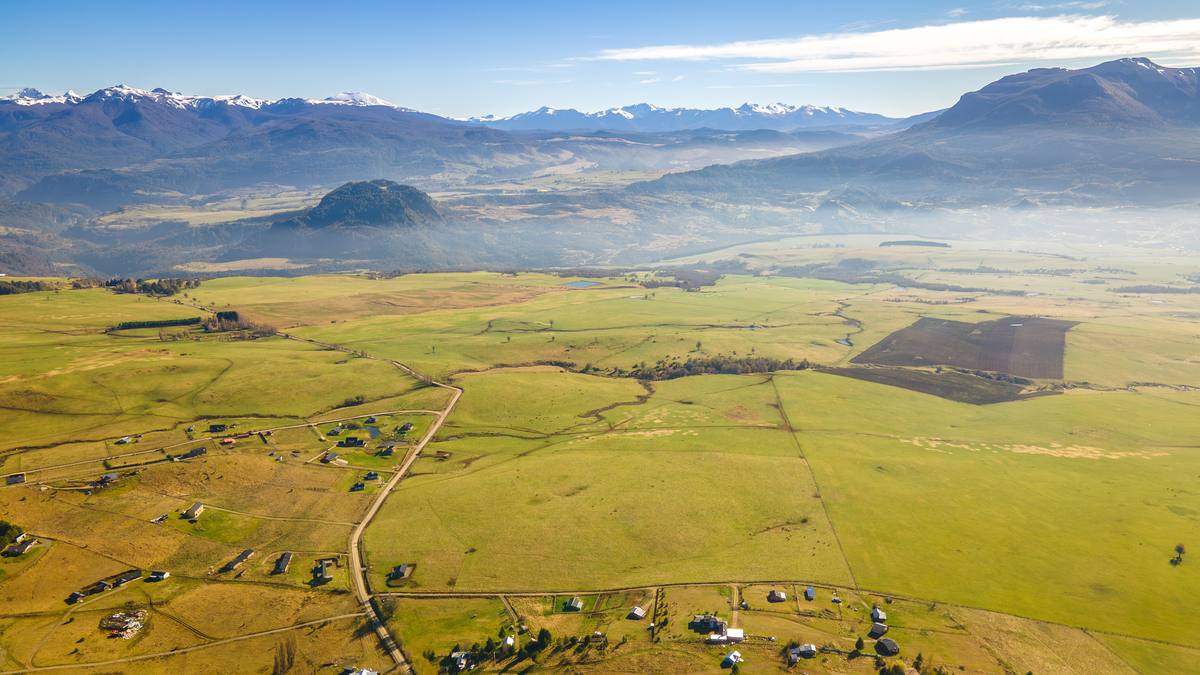 Vista aérea amplia del valle con la cordillera nevada al fondo