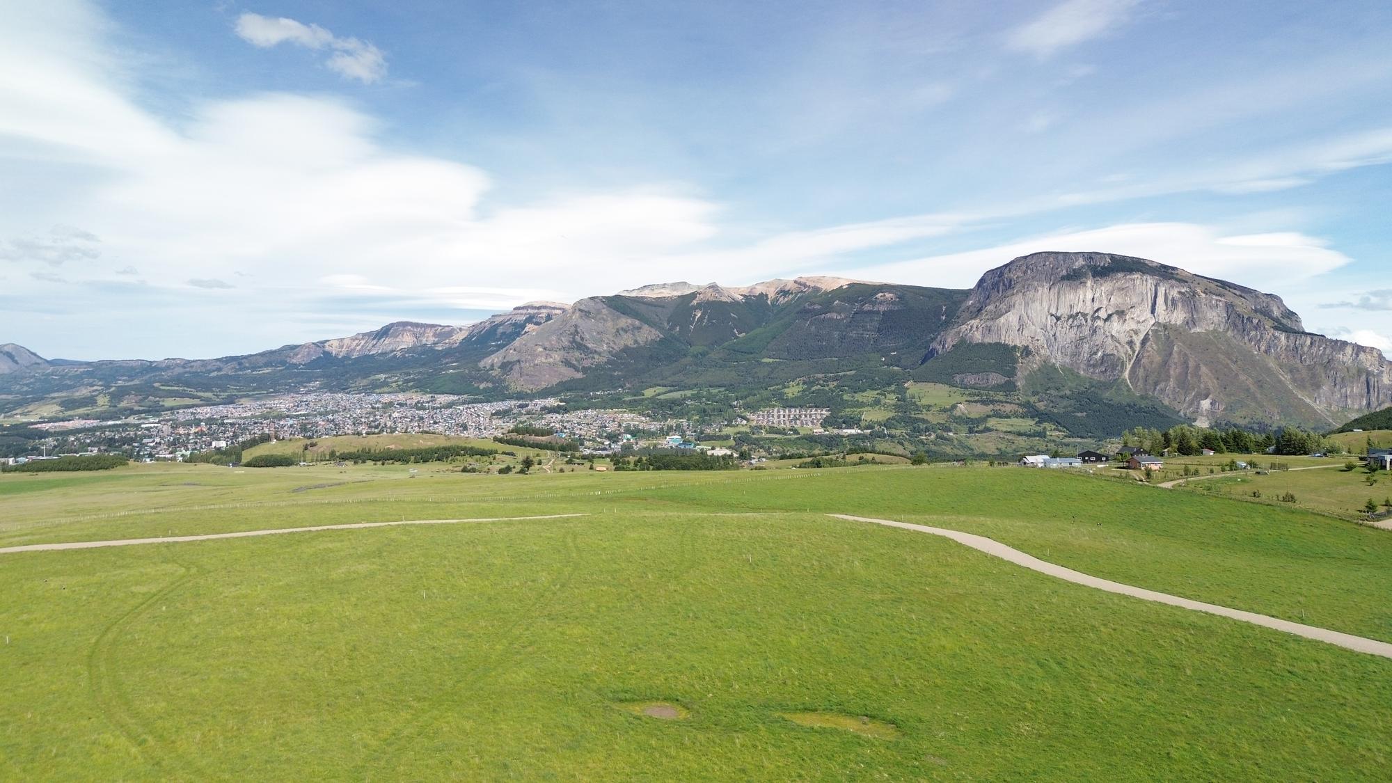Vista aérea del predio con el Cerro Mackay y Coyhaique al fondo